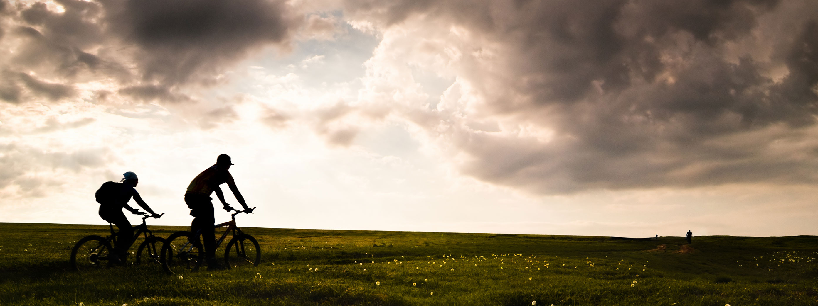 Two people riding bikes in a field